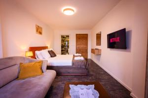 a bedroom with a bed and a couch at Gegë Boutique Hotel in Gjakove