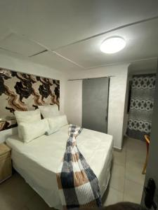 a bedroom with a bed with a tie on it at inspan lodge in Bellville South