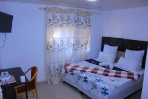 a bedroom with a bed with a curtain and a table at inspan lodge in Bellville South