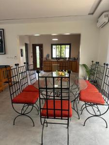 a dining room with chairs and a glass table at Ker Ar Mor - Villa 3 chambres avec piscine privée à Nguerigne in Sintiân +11 photos