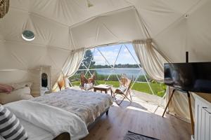 a bedroom with a bed and a tv in a tent at Lake Glamp Mikołajki - Adults Only in Mikołajki
