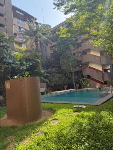 a swimming pool in front of a building at Harmonie in Abidjan