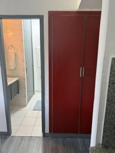a bathroom with a red door and a walk in shower at Harmonie in Abidjan +4 photos