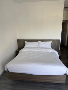 a large bed with white sheets and pillows at Harmonie in Abidjan