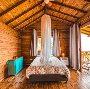 a bedroom with a bed in a wooden house at REFUGIO el CAMPANO in Minca