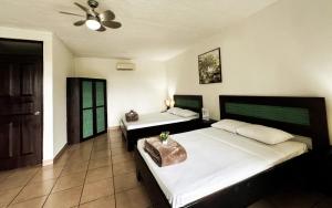 a bedroom with two beds and a ceiling fan at Tabulia Tree Hotel and Villas in Manuel Antonio +24 photos