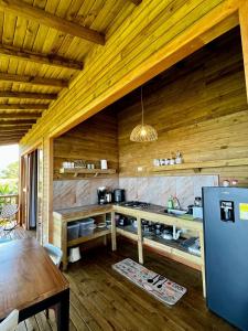 a kitchen with wooden walls and a table and a refrigerator at REFUGIO el CAMPANO in Minca