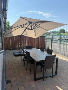 a table and chairs under an umbrella on a patio at Large four bedroom town centre house in Killarney