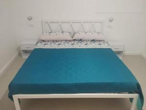 a large bed with a blue blanket on it at Casa Annina in Basilicata in Trivigno