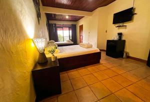 a bedroom with a bed and a television in it at Tabulia Tree Hotel and Villas in Manuel Antonio