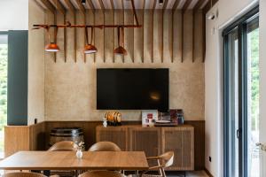 a dining room with a tv and a table at Odat n'Bogë - Breakfast Included by PikHost in Bogë