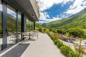 a balcony with tables and chairs overlooking a valley at Odat n'Bogë - Breakfast Included by PikHost in Bogë
