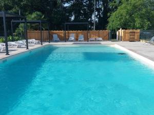 a large pool with blue water in a yard at Insolite hobbit in Saint-André-dʼAllas