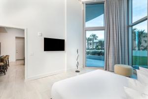 a white bedroom with a large bed and a large window at Max Beach Resort in Daytona Beach +142 photos