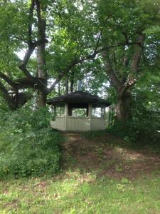 a small house in the middle of a field with trees at Ruissalo Cottage in Turku +1 photo