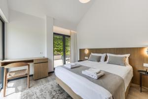 a bedroom with a large bed with towels on it at Odat n'Bogë - Breakfast Included by PikHost in Bogë