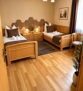 two beds in a room with wooden floors at Templer zum Gasthof in Lochenhaus