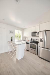 a kitchen with white cabinets and stainless steel appliances at Waterfront Cabana 3 Key Largo in Key Largo +36 photos