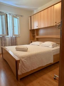 a bedroom with a large bed with wooden cabinets at Apartmani Petra i Igor in Makarska