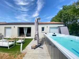a backyard with a swimming pool and an umbrella at La Maison Moderne - 6 pers - SPA - Piscine in Saint-Sauveur-dʼAunis