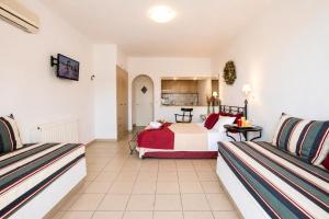 a hotel room with a bed and two seats at 9 Muses in Andros