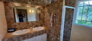 a man taking a picture of a bathroom with two sinks at Le mas christiane in Buis-les-Baronnies +19 photos