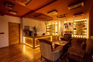 a living room with chairs and a table and wine racks at Gegë Boutique Hotel in Gjakove