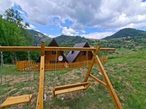a swing set in front of a log cabin at Vikendica Neven 2 in Zaovine