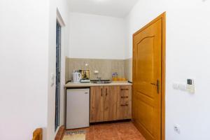a kitchen with a sink and a wooden door at Hostel Backpacker in Ulcinj