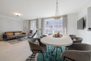 a living room with a table and chairs and a couch at Landhaus Sylter Hahn in Westerland