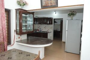 a kitchen with a counter and a refrigerator at VJ Riverfront Villa in Champakulam