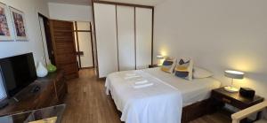 a hotel room with a bed and a flat screen tv at At the beach with a private garden in Carcavelos +11 photos