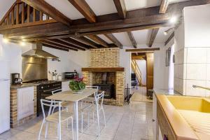 a kitchen with a table and chairs and a stove at Gîte avec jacuzzi La Halte de Chambord in Mur-de-Sologne