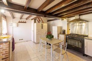 a kitchen with a table and a stove at Gîte avec jacuzzi La Halte de Chambord in Mur-de-Sologne