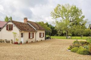 a small white house with a gravel driveway at Gîte avec jacuzzi La Halte de Chambord in Mur-de-Sologne
