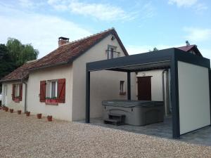 a detached house with a large grill in front of it at Gîte avec jacuzzi La Halte de Chambord in Mur-de-Sologne +4 photos