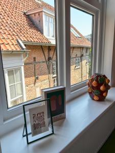 a window sill with two pictures and a vase on it at B&B Bistro Lochem in Lochem +23 photos