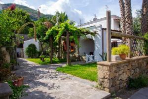 a house with a stone wall next to a street at Residence Parco Gioconda in Forio d'Ischia