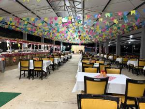 a dining hall with tables and chairs and colorful flags at Hotel fazenda Floresta do Lago in Socorro