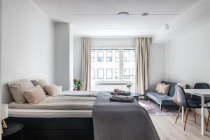 a bedroom with a bed and a couch and a table at Modern Studio in Downtown Lahti in Lahti