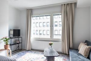 a living room with a couch and a large window at Modern Studio in Downtown Lahti in Lahti