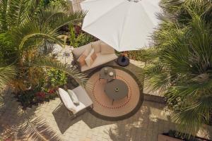 an overhead view of a table and chairs with an umbrella at Villa IV - PRIVATE LIVING in Alghero