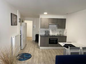 a kitchen with a refrigerator and a table with chairs at Studio cosy au vieux centre in Cormeilles-en-Parisis