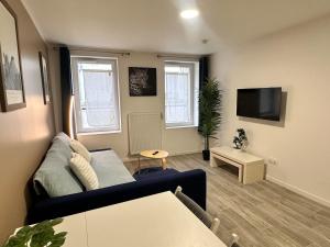 a living room with a couch and a tv at Studio cosy au vieux centre in Cormeilles-en-Parisis