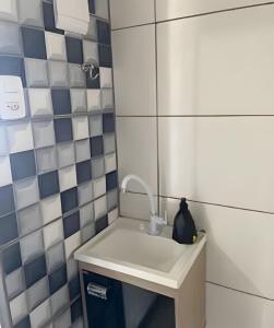 a bathroom with a sink and blue and white tiles at Mini Privativa CA1 - Tiradentes / MG in Belo Horizonte +16 photos