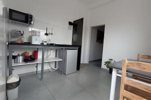 a kitchen with white cabinets and a counter top at Mini Privativa CA1 - Tiradentes / MG in Belo Horizonte