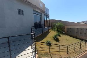 a house with a fence next to a building at Mini Privativa CA1 - Tiradentes / MG in Belo Horizonte