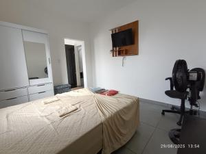a bedroom with a bed and a chair and a mirror at Mini Privativa CA1 - Tiradentes / MG in Belo Horizonte
