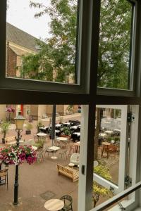 a window view of a patio with tables and chairs at B&B Bistro Lochem in Lochem