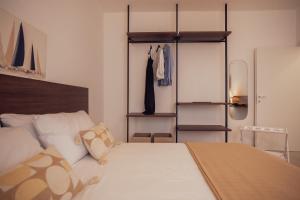 a bedroom with a bed and some clothes racks at Villa IV - PRIVATE LIVING in Alghero
